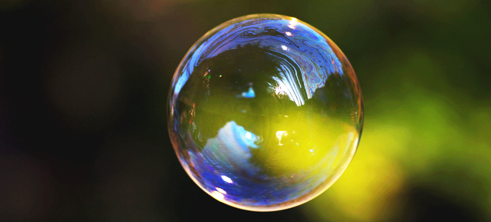 Boy inflating a giant bubble